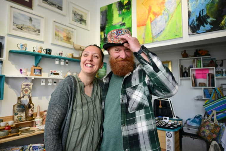 La bijoutière Roxana Saraev et son mari Claudiu dans leur boutique à Sulina le 9 mai 2026 en Roumanie ( AFP / Daniel MIHAILESCU )