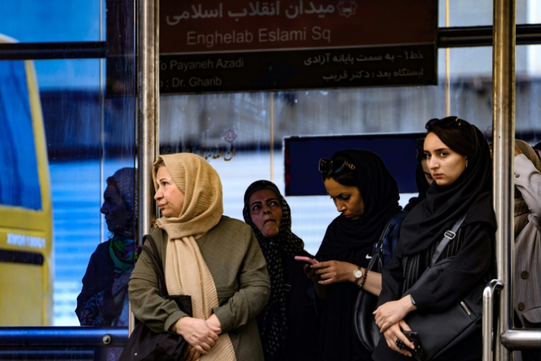 Des Iraniennes attendent devant une station de transport public à Téhéran, le 28 septembre 2025  ( AFP / ATTA KENARE )