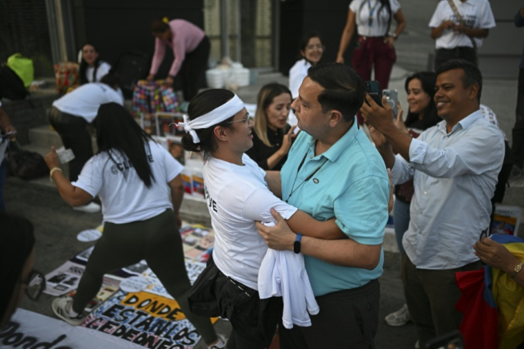 Le militant des droits de l'homme Javier Tarazona (c,d), libéré de prison, salue des proches de prisonniers politiques lors d'une manifestation réclamant leur libération devant le siège du Service bolivarien de renseignement national (SEBIN), à Caracas, le 1er février 2026 au Venezuela ( AFP / Federico PARRA )