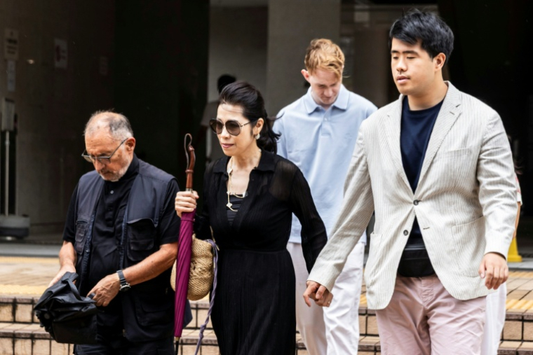 Teresa Lai, l'épouse de Jimmy Lai, et leur fils  Lai Shun Yan (à droite) quittent le tribunal de Hong Kong où le magnat des médias est jugé, le 15 août 2025 ( AFP / ISAAC LAWRENCE )