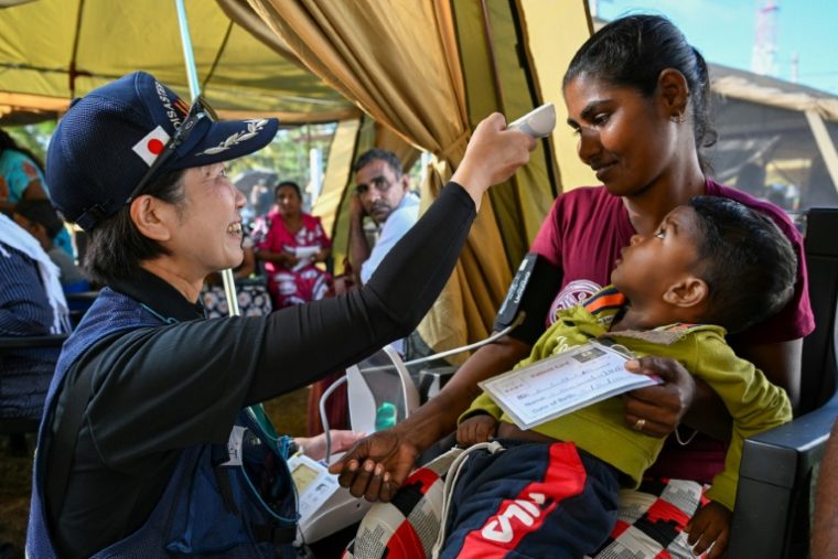 Une patiente et son enfant au camp médical d'urgence de Chilaw au Sri Lanka le 9 décembre 2025. ( AFP / Ishara S. KODIKARA )