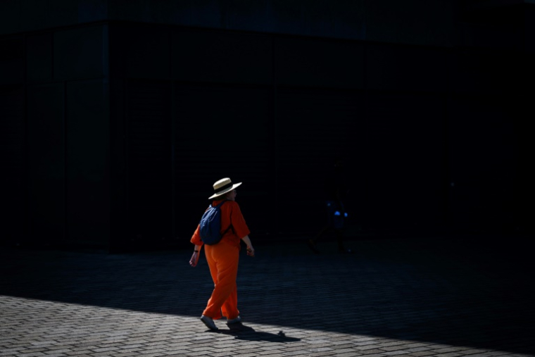 Une femme marche vers l'ombre, à Nantes, le 19 juin 2025 ( AFP / Loic VENANCE )