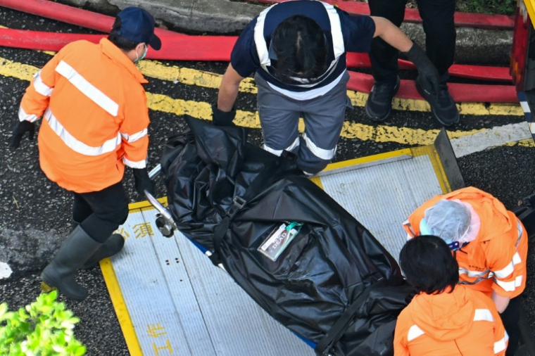 Un corps est transféré dans un véhicule après un important incendie qui a dévasté des tours d'habitation à Hong Kong, le 28 novembre 2025 ( AFP / Peter PARKS )