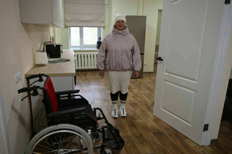 Olga, déplacée par la guerre, pose dans un appartement entièrement rénové dans la ville de Slavoutytch dans le nord de l'Ukraine, le 25 avril 2026  ( AFP / Genya SAVILOV )