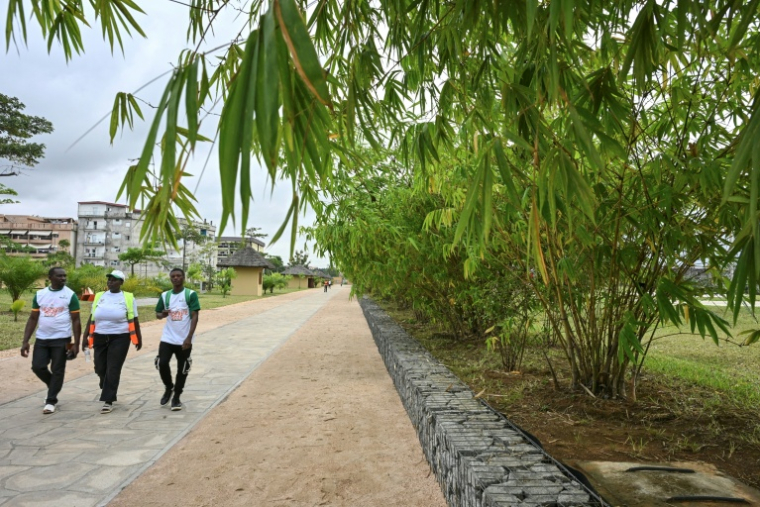Des visiteurs marchent le 1er août 2025 dans le parc urbain d'Akouédo à Abidjan, construit sur le site d'une ancienne décharge ( AFP / Issouf SANOGO )