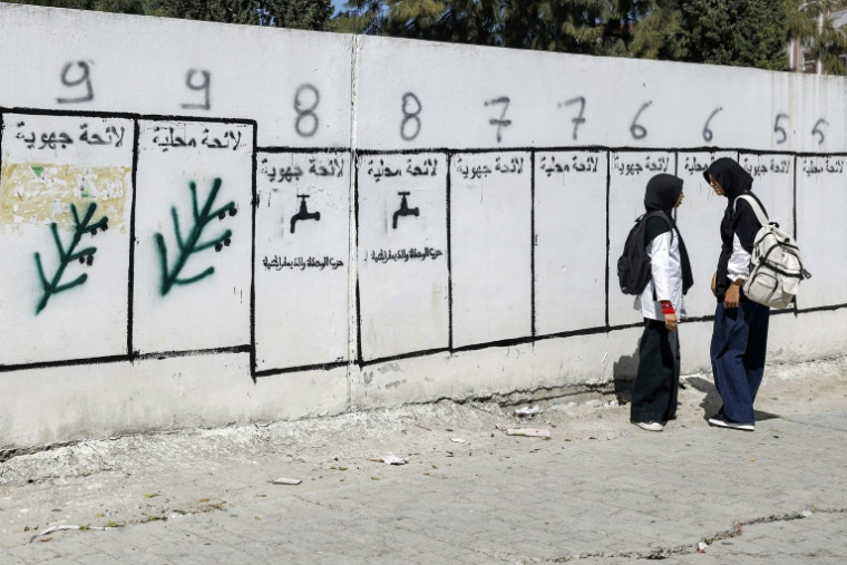 Des jeunes filles passent devant des panneaux pour les élections législatives au Maroc, le 16 septembre 2026 à Tanger ( AFP / Abdel Majid BZIOUAT )