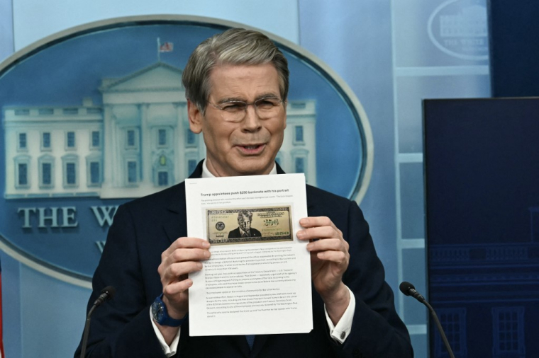 Le ministre des Finances américain, Scott Bessent, présentant l'article évoquant le billet de 250 dollars à l'effigie de Donald Trump lors d'un point presse à la Maison Blanche à Washington le 28 mai 2026. ( AFP / KENT NISHIMURA )