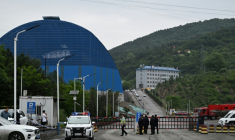 Des policiers et des agents de sécurité gardent la route menant à la mine de charbon de Liushenyu (nord de la Chine), où une explosion a tué des dizaines de personnes, le 24 mai 2026 ( AFP / GREG BAKER )
