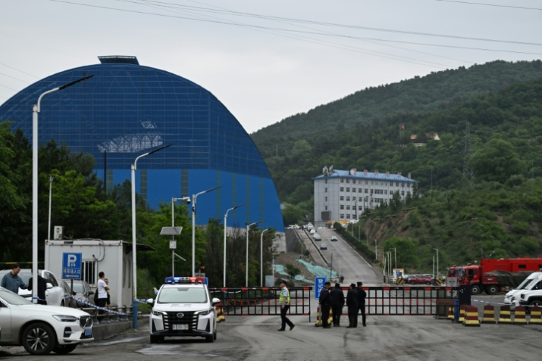 Des policiers et des agents de sécurité gardent la route menant à la mine de charbon de Liushenyu (nord de la Chine), où une explosion a tué des dizaines de personnes, le 24 mai 2026 ( AFP / GREG BAKER )