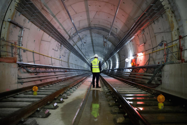 De dos, un employé de la Société des grands projets se tient dans le tunnel avant la dernière soudure des rails de la ligne 15 Sud du nouveau « Grand Paris Express », à la station de métro Clamart le 3 avril 2024. ( AFP / LUDOVIC MARIN )