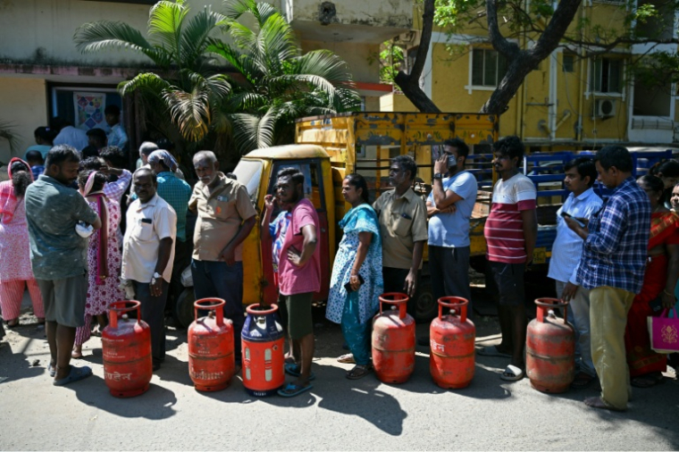 Des Indiens attendent la distribution de bonbonnes de gaz pour une utilisation domestique, à Chennai, le 11 mars 2026, dont la guerre au Moyen-Orient a perturbé les importations  ( AFP / R. Satish BABU )