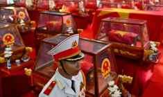 Un soldat à côté de cercueils contenant les dépouilles de soldats tombés au combat au parc Le Thi Rieng, à Hô Chi Minh-Ville , le 14 octobre 2026 au Vietnam ( AFP / Nhac NGUYEN )