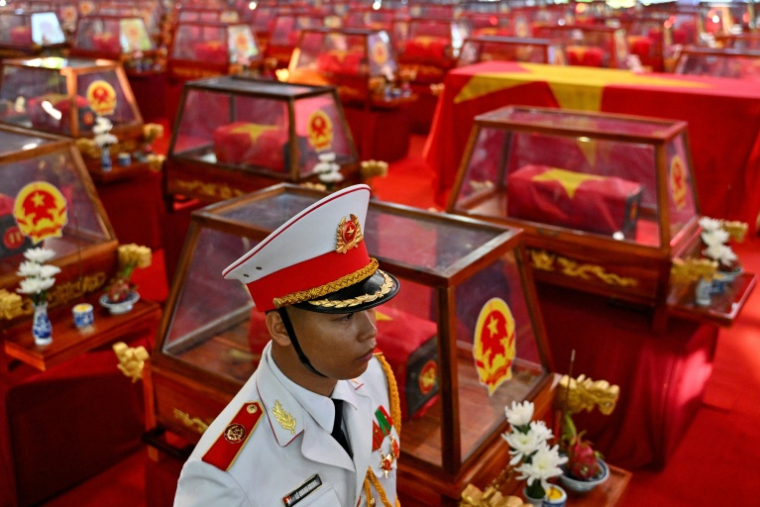 Un soldat à côté de cercueils contenant les dépouilles de soldats tombés au combat au parc Le Thi Rieng, à Hô Chi Minh-Ville , le 14 octobre 2026 au Vietnam ( AFP / Nhac NGUYEN )