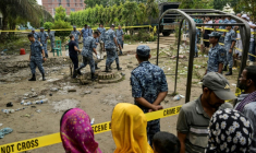Des membres de l'armée de l'air récupèrent des débris au lendemain du crash d'un avion militaire sur une école à Dacca, le 22 juillet 2025 au Bangladesh ( AFP / MUNIR UZ ZAMAN )