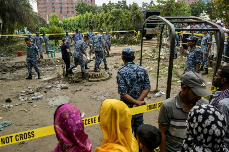 Des membres de l'armée de l'air récupèrent des débris au lendemain du crash d'un avion militaire sur une école à Dacca, le 22 juillet 2025 au Bangladesh ( AFP / MUNIR UZ ZAMAN )