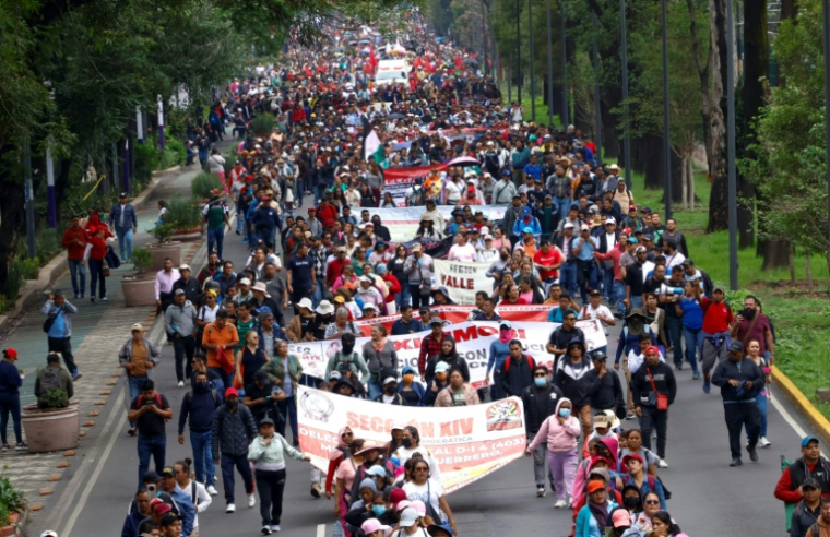 Des enseignants et des élèves marchent vers le stade de Mexico où doivent se dérouler jeudi la cérémonie et le match d'ouverture de la Coupe du monde de football, le 9 juin 2026 au Mexique ( AFP / Gerardo Magallon )