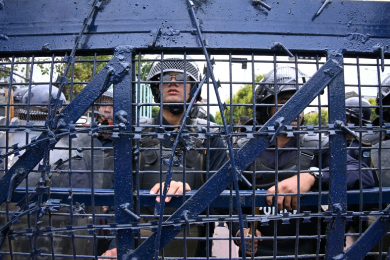 Des policiers montent la garde lors d'une manifestation de partisans de l'ancien Premier ministre népalais KP Sharma Oli protestant contre son arrestation, le 29 mars 2026 à Katmandou, au Népal ( AFP / PRAKASH MATHEMA )
