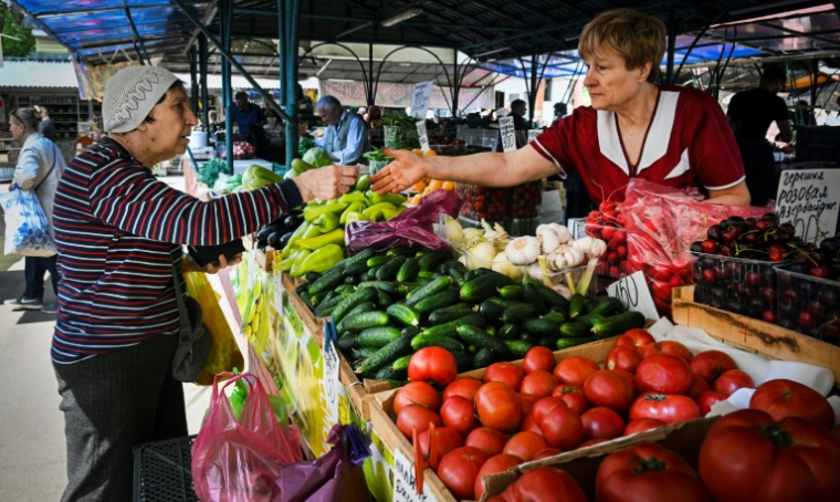 Une femme paie ses légumes sur un marché à Moscou, le 10 juin 2025 ( AFP / Alexander NEMENOV )