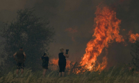 Une habitante filme un incendie à Tournissan, dans l'Aude, le 5 août 2025 ( AFP / IDRISS BIGOU-GILLES )