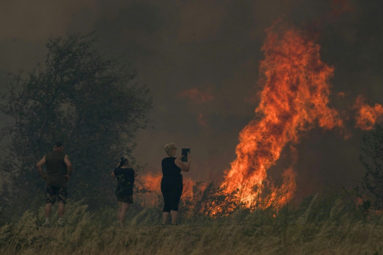 Une habitante filme un incendie à Tournissan, dans l'Aude, le 5 août 2025 ( AFP / IDRISS BIGOU-GILLES )
