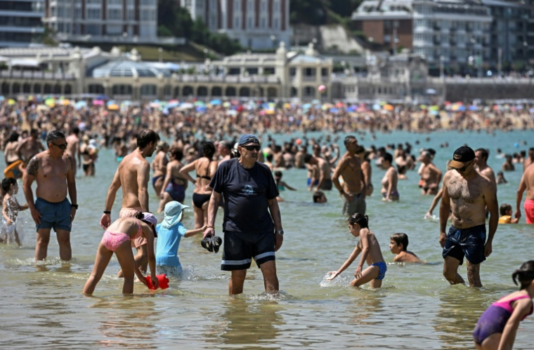 Des personnes se rafraîchissent dans l'eau à la plage de La Concha, dans la ville basque espagnole de Saint-Sébastien, le 21 juin 2026 ( AFP / ANDER GILLENEA )