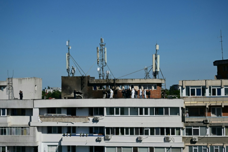 Des policiers et enquêteurs sur le lieu d'impact après qu'un drone russe a percuté un immeuble d'habitation à Galati, le 29 mai 2026 dans l'est de la Roumanie ( AFP / Daniel MIHAILESCU )
