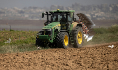 Un agriculteur en tracteur dans un champ agricole près de la frontière entre le sud d'Israël et la bande de Gaza, le 21 mai 2025 ( AFP / Menahem Kahana )