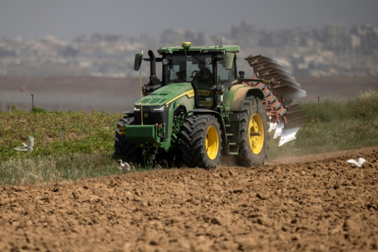 Un agriculteur en tracteur dans un champ agricole près de la frontière entre le sud d'Israël et la bande de Gaza, le 21 mai 2025 ( AFP / Menahem Kahana )