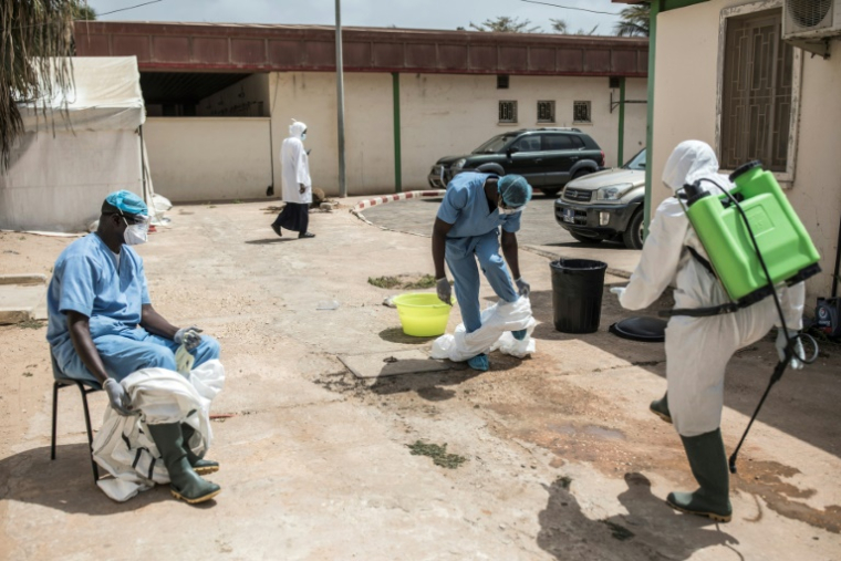 Des agents de santé se désinfectent après avoir effectué des prélèvements sur des patients à l'intérieur d'un service de traitement du Covid-19 à l'hôpital de Pikine à Dakar, le 23 avril 2020 au Sénégal ( AFP / JOHN WESSELS )