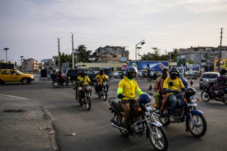 Des motos taxis dans une rue de Cotonou après que des militaires ont annoncé à la télévision publique avoir "démis de ses fonctions" le président Patrice Talon, le 7 décembre 2025 au Bénin ( AFP / OLYMPIA DE MAISMONT )