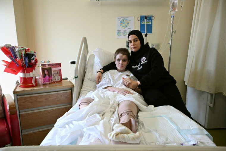 La Libanaise Amani Bazzi, à droite, avec sa fille Aseel, 13 ans, grièvement blessée dans une frappe israélienne, dans un hôpital de Beyrouth, le 25 novembre 2025  ( AFP / Joseph EID )
