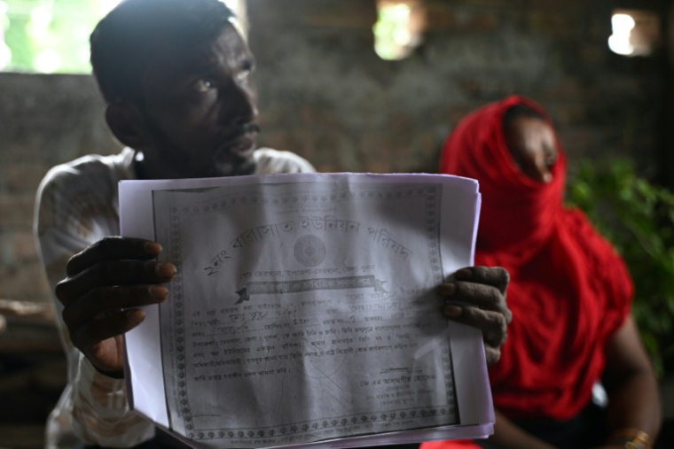 Des migrants bangladais arrivent pour vérification près du camp de la Force de sécurité des frontières indienne (BSF) à Hakimpur, à 80 km de Calcutta (nord-est de l'Inde), le 28 mai 2026 ( AFP / Dibyangshu SARKAR )