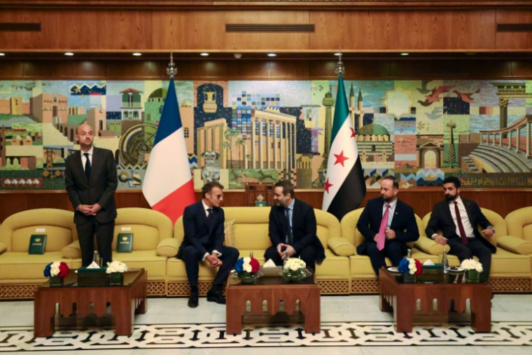 Le président français Emmanuel Macron (2e g) s'entretient avec le ministre syrien des Affaires étrangères Assaad al-Chaibani (c,d), aux côtés du ministre français des Affaires étrangères Jean-Noël Barrot (g), lors d'une rencontre bilatérale à l'aéroport international de Damas, le 6 juillet 2026 en Syrie ( AFP / Ludovic MARIN )
