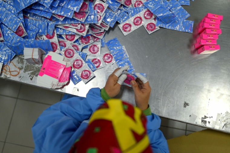 Un employé emballe des préservatifs au siège du fabricant malaisien de préservatifs Karex Industries, à Port Klang, le 20 septembre 2017 ( AFP / MANAN VATSYAYANA )