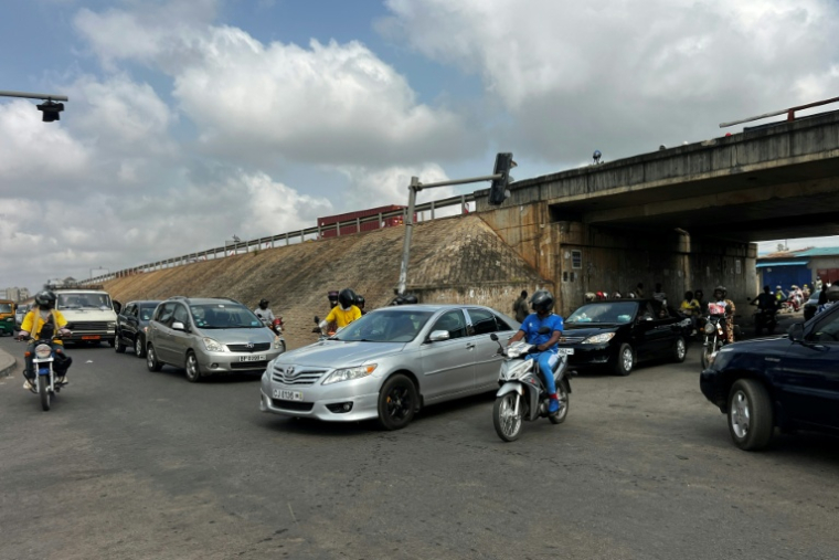 Des automobilistes à Cotonou après que des militaires ont annoncé à la télévision publique du Bénin avoir "démis de ses fonctions" le président Patrice Talon, le 7 décembre 2025 ( AFP / - )