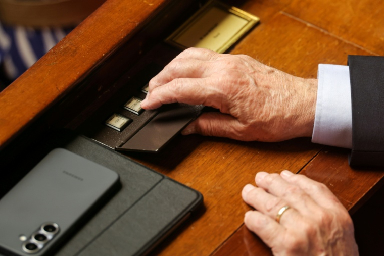 Un député vote sur sur le nouveau projet de loi créant un droit à l'aide à mourir, à l'Assemblée nationale, le 30 juin 2026 à Paris ( AFP / Kenzo TRIBOUILLARD )