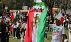 Un manifestant brandit un drapeau iranien d'avant la Révolution islamique, avec une pancarte "Libérez l'Iran", lors d'une manifestation à Los Angeles, le 18 janvier 2026 ( AFP / Jonathan Alcorn )