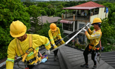 Des ouvriers installent des panneaux solaires sur un toit à Carmona, aux Philippines, le 9 juillet 2026 ( AFP / Jam STA ROSA )