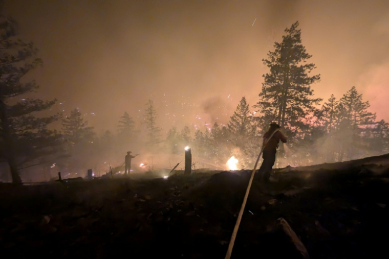 Photo prise le 7 août 2026 et diffusée le lendemain par le Service canadien de la faune de Colombie-Britannique montrant des pompiers luttant contre un incendie de forêt près de Summerland, dans l’ouest du Canada ( BC Wildfire Service / Handout )