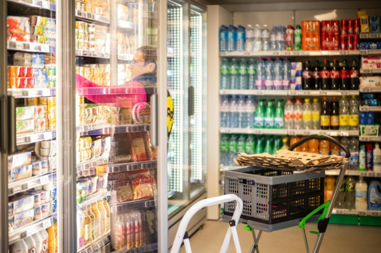 Une employée de la société Api remplit les rayons d'une superette en libre-service sans caissier à Claix, le 1er décembre 2022 en Charente ( AFP / YOHAN BONNET )