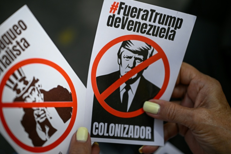 Une femme tient des tracts représentant le président américain Donald Trump et la figure de l'Oncle Sam lors d'une manifestation contre l'ingérence américaine au Venezuela, sur la place El Venezolano à Caracas, le 4 août 2026 ( AFP / Federico PARRA )