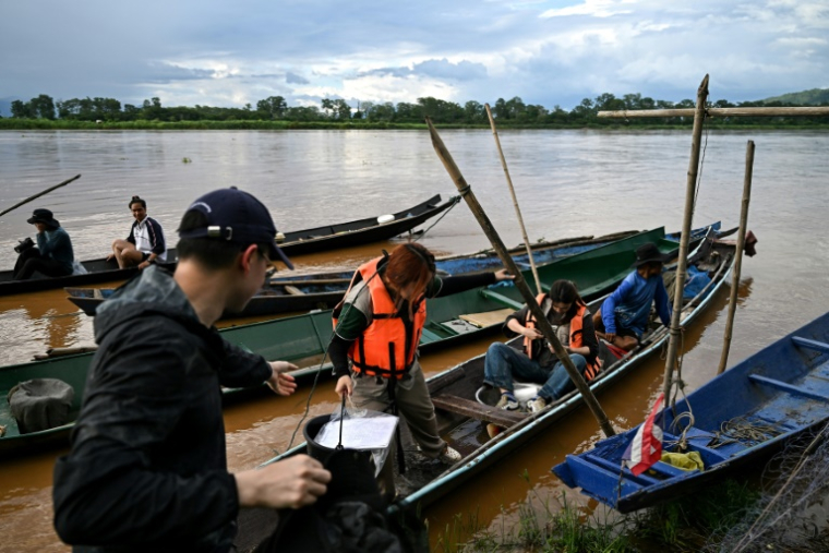 Des étudiants de l'université de Chiang Mai collectent des échantillons pour tester un empoisonnement présumé à l'arsenic le long de la rivière Kok dans la région du Triangle d'or, dans la province de Chiang Rai, dans le nord de la Thaïlande, le 25 mai 2025 ( AFP / Manan VATSYAYANA )