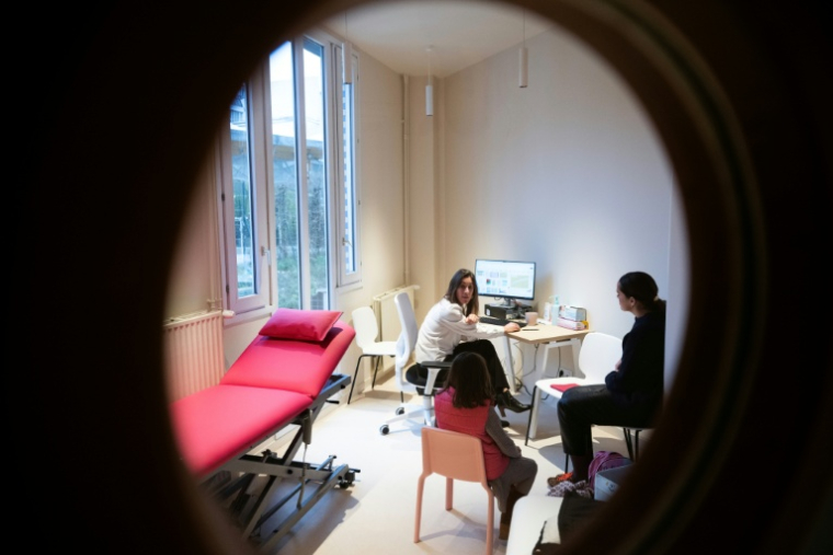 Un professionnel de santé reçoit une jeune fille pour une consultation psychologique à Asterya, le premier centre de santé dédié aux enfants victimes de violence et confiés aux services de l'aide sociale à l'enfance à Paris, le 2 décembre 2025 ( AFP / JULIEN DE ROSA )