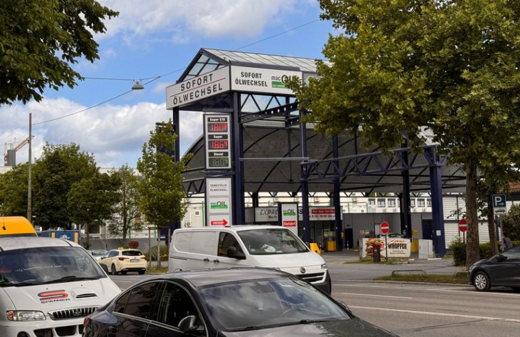 Des voitures passent devant un panneau d'affichage indiquant les prix actuels de l'essence et du diesel dans une station-service, à Munich