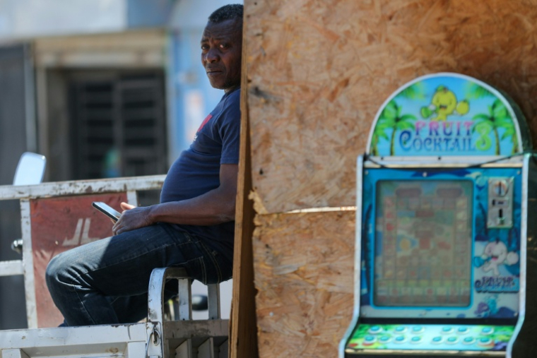 Un homme est assis dans le quartier Nuevo Amanecer, à Santiago du Chili, le 11 novembre 2025 ( AFP / Javier TORRES )
