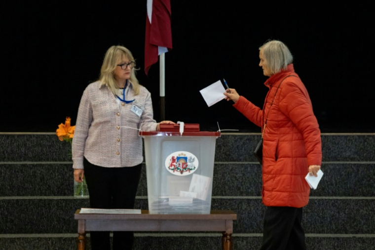 Dans un bureau de vote de Riga le 3 octobre 2026 ( AFP / Wojtek RADWANSKI )