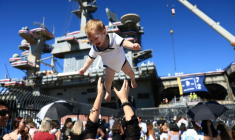 Des familles se réjouissent à l'arrivée du porte-avions américains USS Abraham Lincoln sur la base navale de San Diego, en Californie, le 8 octobre 2026 ( AFP / David Swanson )