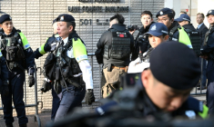 Des policiers devant le tribunal de Kowloon pour le prononcé de la peine du magnat des médias pro-démocratie Jimmy Lai, le 9 février 2026 à Kong Kong ( AFP / Peter PARKS )