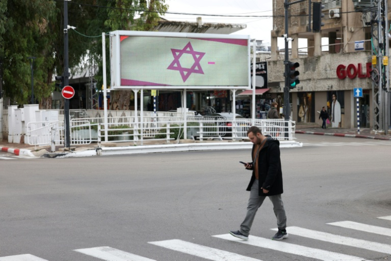 Un passant dans une rue de Nahariya, ville côtière du nord d'Israël, à une vingtaine de kilomètres de la frontière libanaise, le 27 novembre 2024 ( AFP / AHMAD GHARABLI )