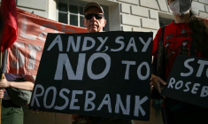 Un homme tient une pancarte contre le projet de champ pétrolier Rosebank, en mer du Nord; au large de l'Écosse, alors que des militants  écologistes manifestent à Londres, le 22 juillet 2026 ( AFP / JUSTIN TALLIS )